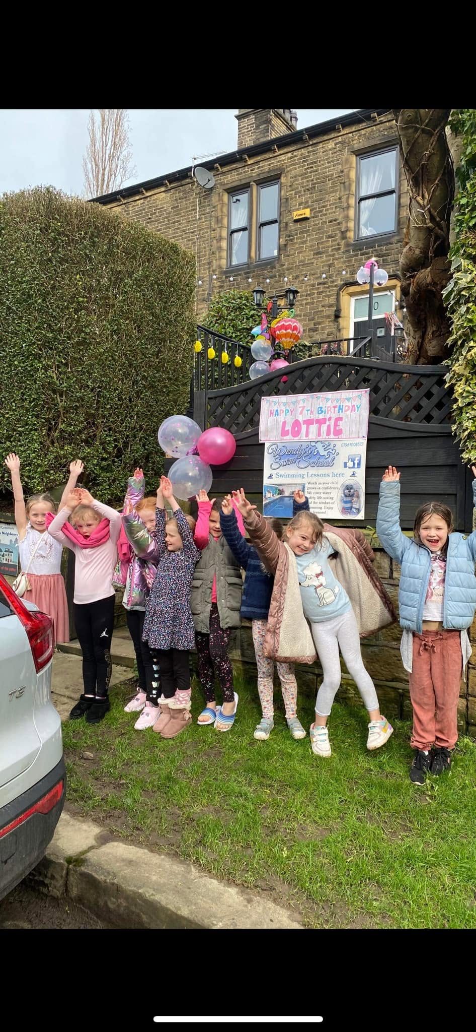 Balloons and a birthday banner beside the Wendy's Swim School sign outside the school